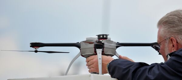 A technician prepares an unmanned surveillance drone at the Defence and Security Equipment International (DSEI) arms fair at the ExCeL centre in east London, on September 10, 2013 - Sputnik International