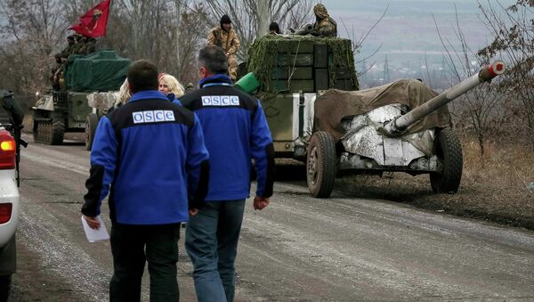 Members of Special Monitoring Mission of the Organization for Security and Cooperation (OSCE) to Ukraine walk along a convoy of Ukrainian armed forces in Paraskoviyvka, eastern Ukraine, February 26, 2015 - Sputnik International