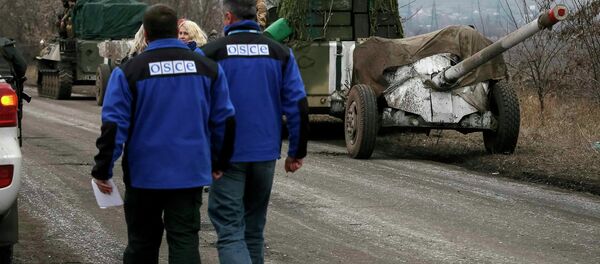 Members of Special Monitoring Mission of the Organization for Security and Cooperation (OSCE) to Ukraine walk along a convoy of Ukrainian armed forces in Paraskoviyvka, eastern Ukraine, February 26, 2015 Members of Special Monitoring Mission of the Organization for Security and Cooperation (OSCE) to Ukraine walk along a convoy of Ukrainian armed forces in Paraskoviyvka, eastern Ukraine, February 26, 2015 - Sputnik International