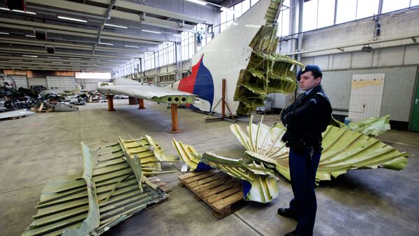 Dutch military police stand next to parts of the wreckage of the Malaysia Airlines Flight 17, displayed in a hangar at Gilze-Rijen airbase, Netherlands, Tuesday, March 3, 2015 - Sputnik International