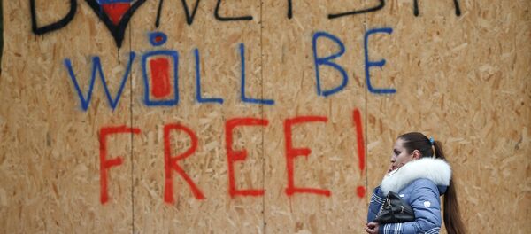 A woman walks by shop windows protected from possible shelling with wooden boards with the inscription Donetsk will be free in Donetsk, Ukraine, Sunday, March 1, 2015 A woman walks by shop windows protected from possible shelling with wooden boards with the inscription Donetsk will be free in Donetsk, Ukraine, Sunday, March 1, 2015 - Sputnik International