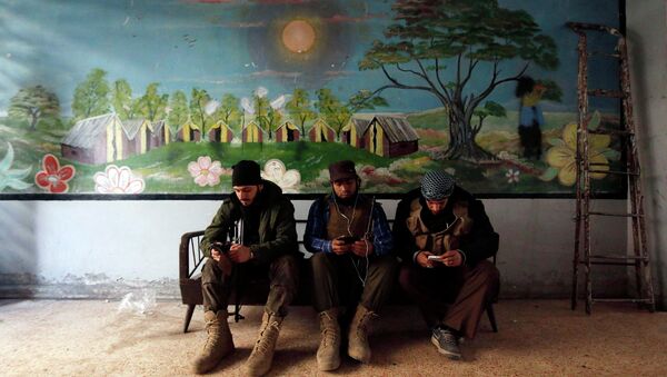 Rebel fighters of 'Al-Sultan Murad' brigade use their mobile phones inside a room near the frontline in Handarat area, north of Aleppo March 1, 2015 - Sputnik International