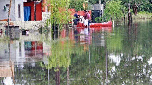 Residents remain near a boat in a flooded street due to heavy rains in Balnearia, Cordoba province, Argentina - Sputnik International