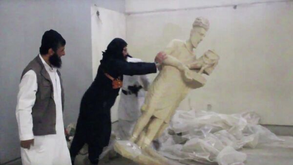 In this image made from video posted on a social media account affiliated with the Islamic State group on Thursday, Feb. 26, 2015, which has been verified and is consistent with other AP reporting, a militant topples an ancient artifact in the Ninevah Museum in Mosul, Iraq - Sputnik International