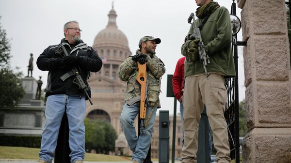 In this 13 January 2015 file photo, gun rights advocates carry rifles while protesting outside the Texas Capitol in Austin, Texas - Sputnik International