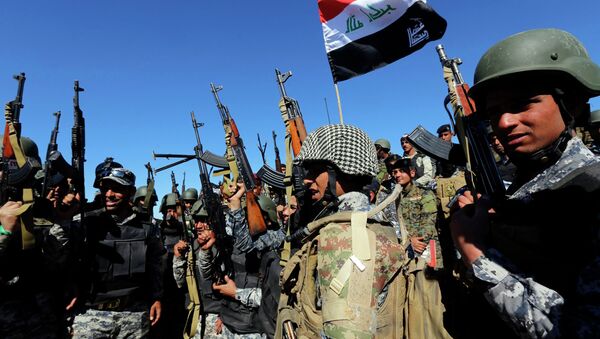 Members of the Iraqi security forces chant slogans in Al Hadidiya, south of Tikrit, en route to the Islamic State-controlled al-Alam town, where they are preparing to launch an offensive on Saturday, March 6, 2015 - Sputnik International
