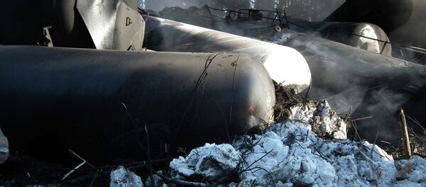 Tanker rail cars are seen lying on their side after a crude oil train derailment Tanker rail cars are seen lying on their side after a crude oil train derailment - Sputnik International