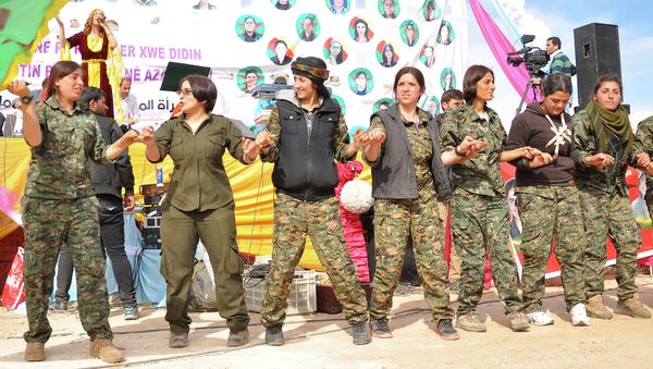 Women fighters from the People's Protection Units (YPG) dance during festivities on the eve of International Women's Day in Syria's northeastern city of Qamishli in the Hasakeh province, on the border with Turkey - Sputnik International