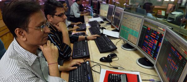 Indian stock dealers watch stock prices on their screen during intra-day trade at a brokerage house in Mumbai - Sputnik International