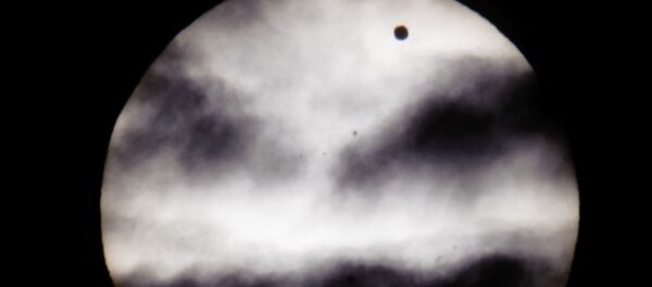 The larger black dot, top right, is the planet Venus as it transits across the face of the Sun as viewed from Earth in Budapest, Hungary - Sputnik International