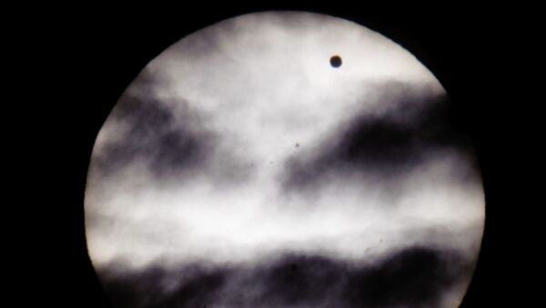The larger black dot, top right, is the planet Venus as it transits across the face of the Sun as viewed from Earth in Budapest, Hungary - Sputnik International