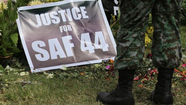 A Philippine police commando stands near a poster calling for justice for 44 commandos killed in a clash with Muslim rebels in January. - Sputnik International