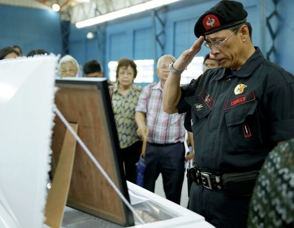 A Philippine National Police officer salutes before the flag-draped coffin of one of the 44 commandos killed in a January clash with Muslim rebels. A Philippine National Police officer salutes before the flag-draped coffin of one of the 44 commandos killed in a January clash with Muslim rebels. - Sputnik International