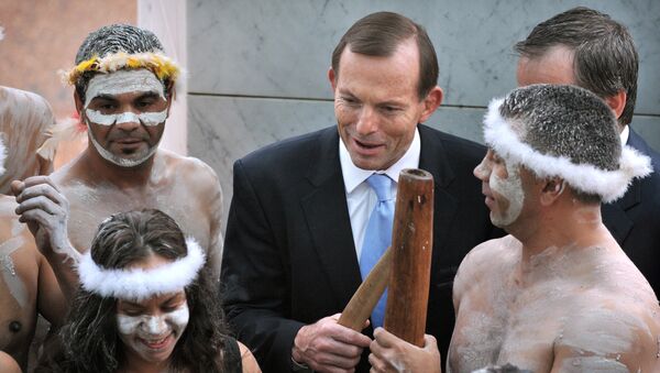 A file photo taken on November 12, 2013, shows Australian Prime Minister Tony Abbott holding his fighting boomerang while talking to an Aboriginal performer at the opening of the 44th Parliament in Canberra. Abbott faced a wave of criticism on March 11, 2015 - Sputnik International