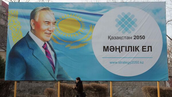 A woman walks past a poster depicting Kazakhstan's President Nursultan Nazarbayev in Almaty February 16, 2015 - Sputnik International