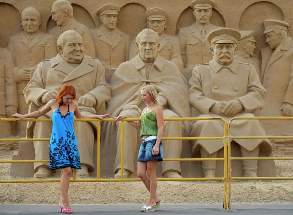 Girls stand in front of a sand sculpture Girls stand in front of a sand sculpture - Sputnik International