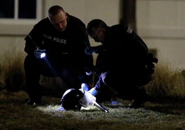 Police shine a light on a helmet as they investigate the scene where two police officers were shot outside the Ferguson Police Department Thursday, March 12, 2015, in Ferguson, Mo Police shine a light on a helmet as they investigate the scene where two police officers were shot outside the Ferguson Police Department Thursday, March 12, 2015, in Ferguson, Mo - Sputnik International