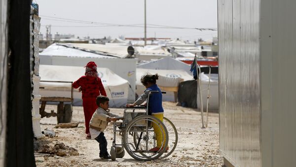 Syrian refugee children play with a wheelchair at the Al Zaatari refugee camp in the Jordanian city of Mafraq, near the border with Syria March 11, 2015 - Sputnik International