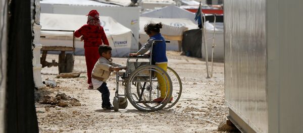 Syrian refugee children play with a wheelchair at the Al Zaatari refugee camp in the Jordanian city of Mafraq, near the border with Syria March 11, 2015 Syrian refugee children play with a wheelchair at the Al Zaatari refugee camp in the Jordanian city of Mafraq, near the border with Syria March 11, 2015 - Sputnik International