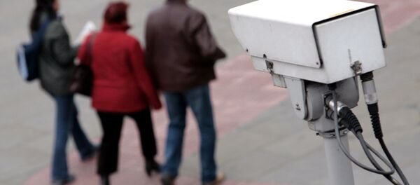 A police CCTV camera observes people walking in the Embankment area of central London - Sputnik International