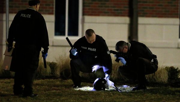 Police shine a light on and photograph a helmet as they investigate the scene where two police officers were shot outside the Ferguson Police Department Thursday, March 12, 2015, in Ferguson, Mo - Sputnik International