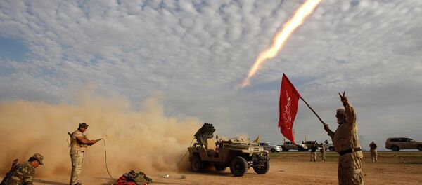 Shi'ite fighters launch a rocket during clashes with Islamic State militants on the outskirts of al-Alam Shi'ite fighters launch a rocket during clashes with Islamic State militants on the outskirts of al-Alam - Sputnik International