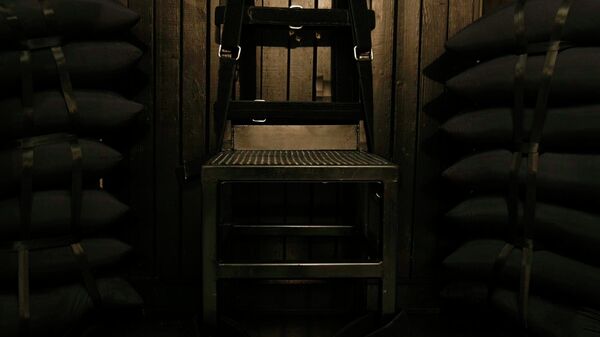 Bullet holes are visible in the wood panel behind the chair in the execution chamber at the Utah State Prison after Ronnie Lee Gardner was executed by firing squad - Sputnik International