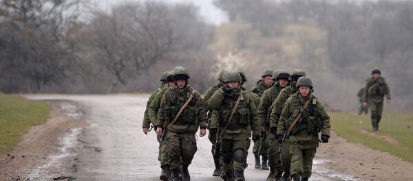 Russian soldiers patrol the area surrounding the Ukrainian military unit in Perevalnoye, outside Simferopol, on March 20, 2014 - Sputnik International