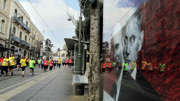 Athletes, participating in the fifth international Jerusalem Marathon, run near a poster of Israeli Prime Minister Benjamin Netanyahu (L) and Naftali Bennett, head of far-right Jewish Home party, four days ahead of parliamentary elections, March 13, 2015 - Sputnik International