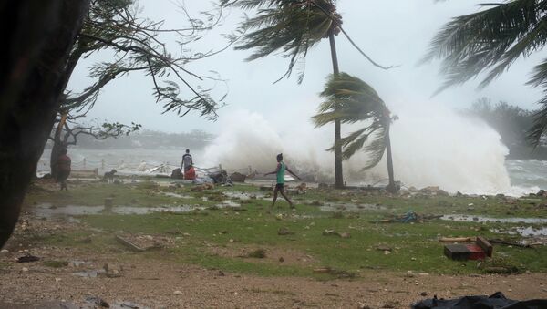 In this image provided by UNICEF Pacific people walk along the shore where debris is scattered in Port Vila, Vanuatu, Saturday, March 14, 2015, in the aftermath of Cyclone Pam - Sputnik International