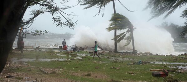 In this image provided by UNICEF Pacific people walk along the shore where debris is scattered in Port Vila, Vanuatu, Saturday, March 14, 2015, in the aftermath of Cyclone Pam - Sputnik International