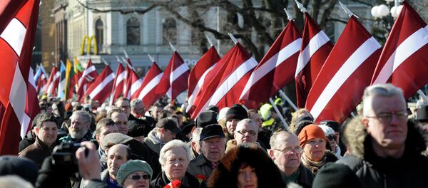 People carry Latvian flags at the march in Riga, Latvia People carry Latvian flags at the march in Riga, Latvia - Sputnik International