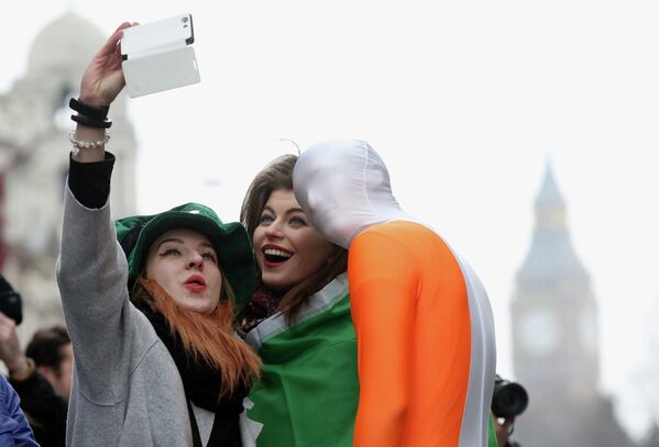 Young women from Moscow have their picture taken with a participant of the St Patrick's Day parade, central London. - Sputnik International