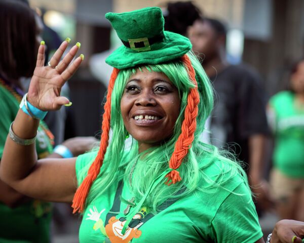 A woman dressed as a leprechaun waves to friends as she walking along River Street during the start of a four-day St. Patrick's Day celebration on River Street in Savannah, Georgia. - Sputnik International