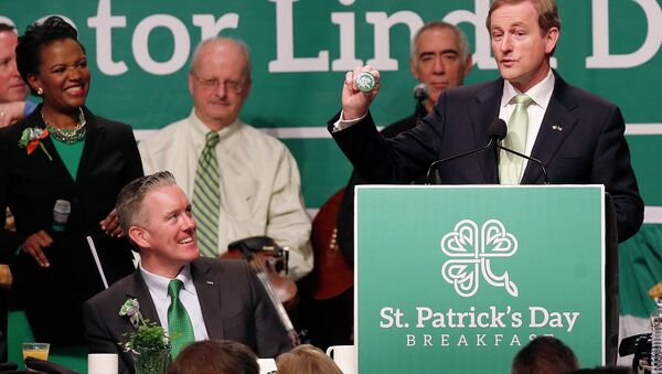 Prime Minister Enda Kenny of Ireland, right, holds a badge while speaking at the annual St. Patrick's Day Breakfast in Boston, as host state Sen. Linda Dorcena Forry, left, looks on, March 16, 2014. - Sputnik International