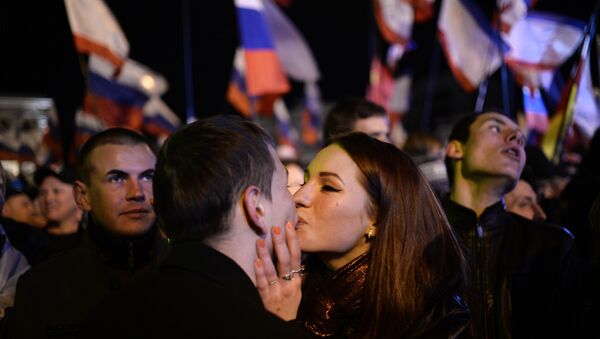 A file picture taken on March 16, 2014 shows a Crimean couple kissing as people celebrate in Simferopol's Lenin Square after exit polls showed that about 93 percent of voters in Ukraine's Crimea region supported union with Russia. - Sputnik International