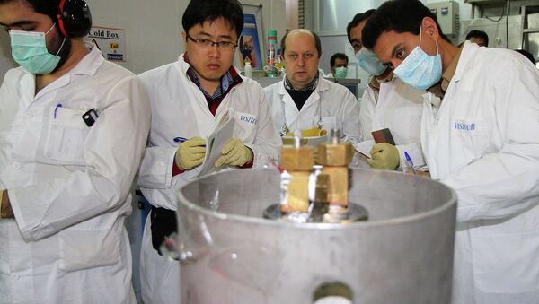 Unidentified International Atomic Energy Agency (IAEA) inspectors (2nd-3rd L) and Iranian technicians disconnect the connections between the twin cascades for 20 percent uranium production at nuclear power plant of Natanz, some 300 kilometres south of Tehran. File photo - Sputnik International