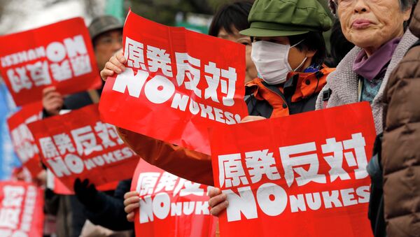 Anti-nuclear protesters hold placards during a rally in Tokyo, Japan, on March 8. - Sputnik International