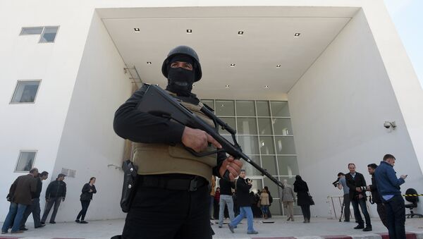 A member of the Tunisian security forces stands guard as journalists gather at the visitors entrance of the National Bardo Museum in Tunis - Sputnik International