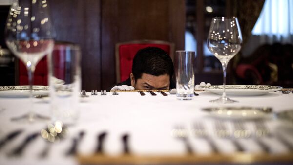 A butler in training inspects the precise distance between cutlery on a table at China's only foreign-run butler school in Chengdu, Sichuan province - Sputnik International