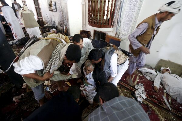  People help an injured man at the scene of a suicide bombing inside a mosque in Sanaa March 20, 2015 - Sputnik International