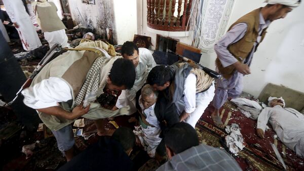 People help an injured man at the scene of a suicide bombing inside a mosque in Sanaa March 20, 2015 - Sputnik International