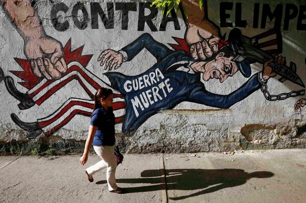 A woman walks past a graffti which reads war dead, in Caracas March 9, 2015 - Sputnik International