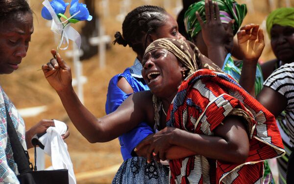 Relatives weep as they bury a loved one suspected of dying from the Ebola virus at a new graveyard on the outskirts of Monrovia, Liberia, March 11, 2015 - Sputnik International