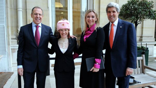 U.S. Department of State Spokesperson Jennifer Psaki -- sporting a shapka, or fur hat with ear flaps, given to her by Russian counterpart Maria Zakharova -- stands with Zakharova between U.S. Secretary of State John Kerry and Russian Foreign Minister Sergey Lavrov in Paris, France, on January 13, 2014 - Sputnik International