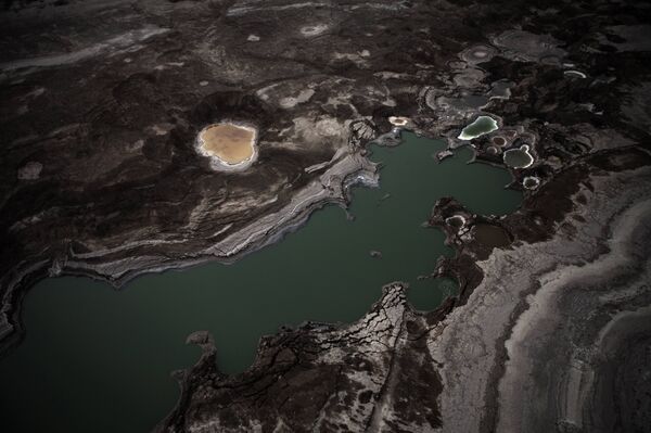 An aerial view photo shows sinkholes created by the drying of the Dead Sea, near Kibbutz Ein Gedi An aerial view photo shows sinkholes created by the drying of the Dead Sea, near Kibbutz Ein Gedi - Sputnik International