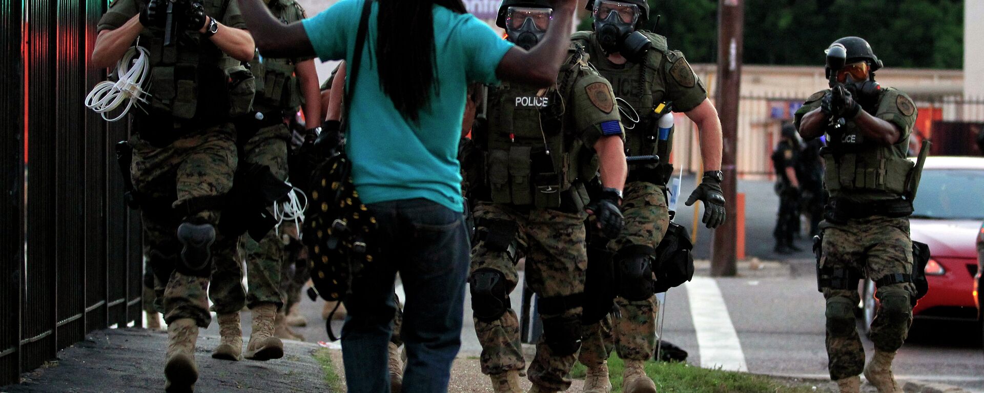 In this Aug. 11, 2014, file photo, police wearing riot gear walk toward a man with his hands raised Monday, Aug. 11, 2014, in Ferguson - Sputnik International, 1920, 12.10.2017