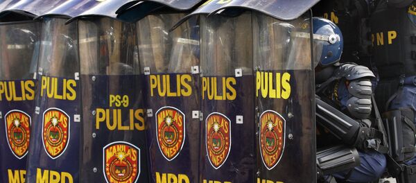 Anti-riot police execute an umbrella formation as a protection against stone throwing protesters during a crowd dispersal management competition in Manila, Philippines - Sputnik International