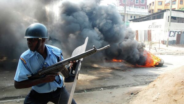 A riot police officer near to a tire on fire, lit by Muslim youths, outside Masjid Musa Mosque, in Majengo, Mombasa, Kenya - Sputnik International