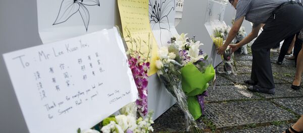 People lay flowers, as they mourn the passing of former prime minister Lee Kuan Yew, outside the Istana in Singapore, March 23, 2015 - Sputnik International
